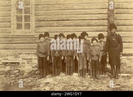 Kinderbildung, 1909. Aus TiPY postroek V stanitsakh Sibirskogo kazach’Ego voiska (Bauformen in den Dörfern des sibirischen Kosakenhebers), einem von drei Alben, die die Gebiete, die Kultur und die Lebensweise der Kosaken darstellen, die in den Steppenregionen Westsibiriens und des heutigen Kasachstans leben. Diese Alben wurden für die erste westsibirische Landwirtschafts-, Forst- und kommerziell-industrielle Ausstellung 1911 in Omsk erstellt und ausgestellt. Die Alben waren Teil einer Sammlung von Fotografien, die zwischen 1891 und 1918 vom Museum der Westsibirischen Zweigstelle zusammengestellt wurden Stockfoto