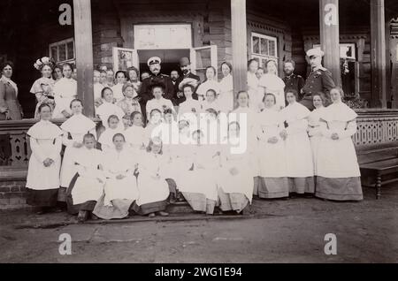 Eine Gruppe von Schülern vom Maiden Institute mit Lehrern auf der Veranda der Datscha, 1900. Diese Sammlung zeigt eine Serie von Fotografien, die von den Podgorbunskiis aufgenommen wurden. Der Vater, I. A. Podgorbunskii, war Priester, Lehrer, Wissenschaftler. und lokaler Historiker. Der Sohn V. I. Podgorbunskii war Archäologe. Ihre Fotografien der Baikalregion zeigen die Landschaft sowie die Lebensweise und Kultur der Anwohner. Städtisches Geschichtsmuseum Irkutsk Stockfoto