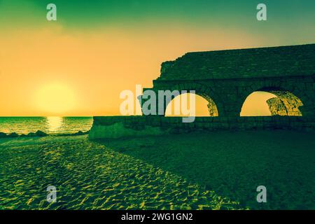 Überreste der alten römischen Wasserleitung in antiken Stadt Caesarea bei Sonnenuntergang. Israel. Stockfoto