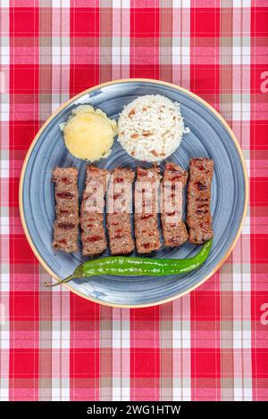 Türkische Küche inegol Fleischbällchen. Gegrillte Fleischbällchen auf einem Teller. Türkischer Tekirdag oder Inegol Kofte mit Pfeffer, Reis und Kartoffelpüree, Kofta. Stockfoto