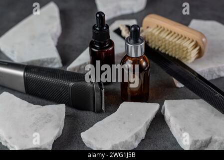 Mann Bartpflege auf Steintischoberfläche, Kamm, Öl und elektrischem Trimmer Stockfoto