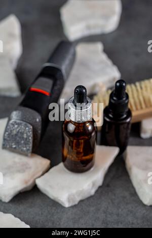 Mann Bartpflege auf Steintischoberfläche, Kamm, Öl und elektrischem Trimmer Stockfoto