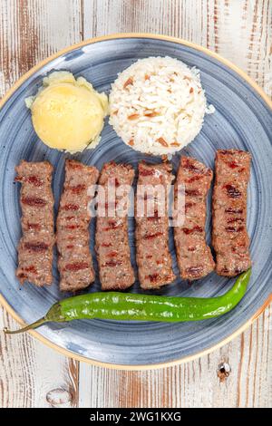 Türkische Küche inegol Fleischbällchen. Gegrillte Fleischbällchen auf einem Teller. Türkischer Tekirdag oder Inegol Kofte mit Pfeffer, Reis und Kartoffelpüree, Kofta. Stockfoto