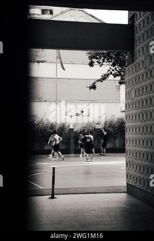 Jungs spielen Basketball auf dem Spielplatz in Shanghai, China Stockfoto