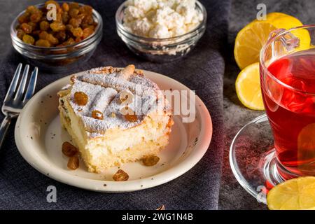 Hausgemachter Käsekuchen mit Rosinen. Käsekuchen mit Rosinen und Zitronenscheiben und Tee Stockfoto