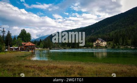 Ein ruhiger, grüner See, eingebettet in hoch aufragende Berge Stockfoto