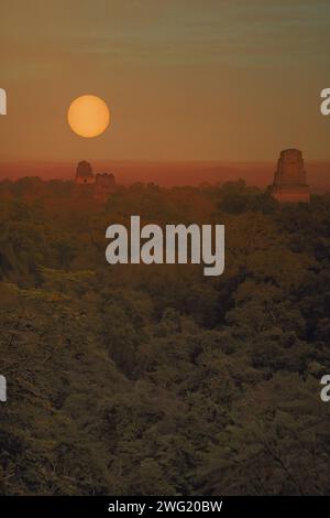 Pyramiden des antiken Maya-Tempelkomplexes von Tikal, die bei Sonnenaufgang über dem Regenwald aufsteigen. Tikal Nationalpark, Peten, Guatemala, Zentralamerika Stockfoto