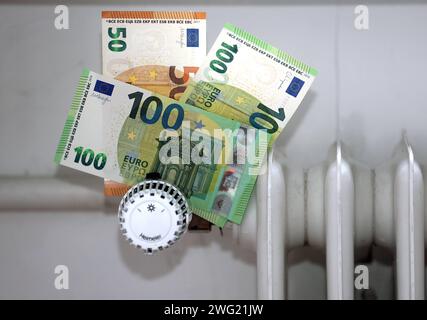 Bayern, Deutschland 02. Februar 2024: Hier im Bild ein Heizungsregler, Thermostat an einem Heizkörper auf dem Geldscheine aufgesteckt sind als Symbol für Teures Heizen, Preissteigerung, Gaspreis, Ölpreis, Heizkosten *** Bavaria, Deutschland 02 Februar 2024 hier im Bild ein Heizungsregler, Thermostat auf einem Heizkörper, auf dem Banknoten als Symbol für teure Heizung, Preiserhöhung, Gaspreis, Ölpreis, Heizkosten angebracht sind Stockfoto