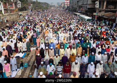 Tongi, Dhaka, Bangladesch. Februar 2024. Muslimische Gläubige beten mitten an einer stark befahrenen Straßenkreuzung, wodurch der Verkehr in Tongi, Dhaka, Bangladesch während der Bishwa Ijtema, einer der wichtigsten islamischen religiösen Zusammenkünfte, die jährlich stattfinden, zum Erliegen kommt. Ein engagiertes Gebetsgelände reicht nicht aus, um diese große Anzahl von Menschen zu bewältigen, so dass eine große Anzahl von Menschen nach Tongi, der Hauptstraße von Dhaka, kommen. Während dieser Zeit sind alle Bodentransporte und Fußgängerübergänge ausgesetzt. Die Bishwa Ijtema (Globale Kongregation) ist eine jährliche Zusammenkunft von Muslimen in Tongi am Ufer des Riv Stockfoto