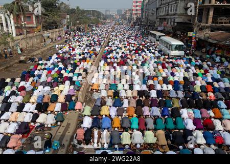 Tongi, Dhaka, Bangladesch. Februar 2024. Muslimische Gläubige beten mitten an einer stark befahrenen Straßenkreuzung, wodurch der Verkehr in Tongi, Dhaka, Bangladesch während der Bishwa Ijtema, einer der wichtigsten islamischen religiösen Zusammenkünfte, die jährlich stattfinden, zum Erliegen kommt. Ein engagiertes Gebetsgelände reicht nicht aus, um diese große Anzahl von Menschen zu bewältigen, so dass eine große Anzahl von Menschen nach Tongi, der Hauptstraße von Dhaka, kommen. Während dieser Zeit sind alle Bodentransporte und Fußgängerübergänge ausgesetzt. Die Bishwa Ijtema (Globale Kongregation) ist eine jährliche Zusammenkunft von Muslimen in Tongi am Ufer des Riv Stockfoto