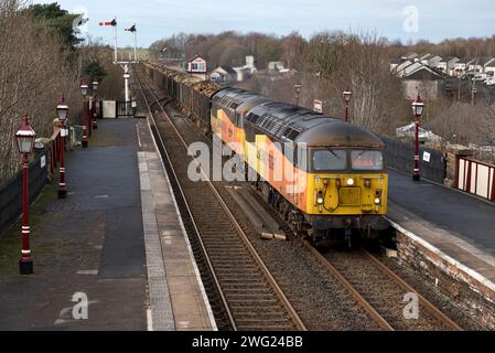 Der Holzzug fährt durch die Appleby Station auf der Settle-Carlisle Railway zu den Kronospan Verarbeitungswerken in Chirk, Wales. Stockfoto