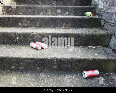 Bierdosen sind auf Stufen draußen verstreut. Stockfoto