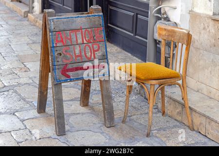 Antik Shop Schild Richtung Arrow Wood Board Leere Chair at Street Stockfoto