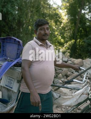 Ein Straßenverkäufer, der Teile auf seinem Fahrrad über Den Fluss in Birendranagar, Provinz Karnali, Westnepalast transportiert. Stockfoto