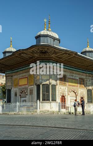 Ein Paar vor dem Brunnen von Sultan Ahmed III., Istanbul, Türkei Stockfoto