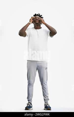 Ein Mann, voller Länge, auf weißem Hintergrund, hielt sich an den Kopf Stockfoto