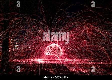 Eine lebendige Ausstellung von Stahlwolle-Fotografien in einem Park bei Nacht Stockfoto