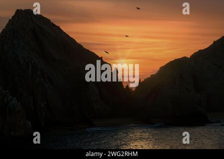 Landende bei Sonnenuntergang, natürlicher Felsbogen und das Meer von Cortez. Stockfoto