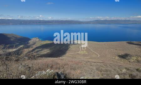 296 Blick nach Westen vom Aussichtspunkt Galicica auf Koritski RID über das Dorf Trpejca und das türkisblaue Wasser des Lake Ohrid. Nordmazedonien. Stockfoto