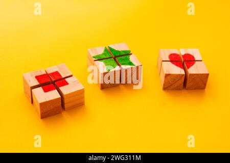Puzzle aus drei Holzwürfeln, die ein Quadrat bilden, einen Stern und ein Herz in der Mitte Stockfoto