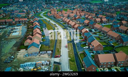 Luftaufnahme eines vorstädtischen Wohnbaus mit laufendem Bau, der das Muster von Wohnstraßen und Wohnhäusern zeigt. Stockfoto