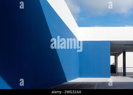Blau-weiße Betonwand mit Sonnenlicht und Schatten Stockfoto