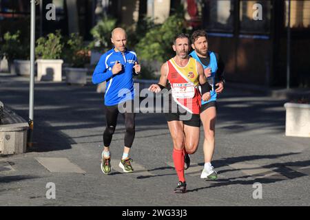 Männer und Frauen nehmen an einem Laufrennen für Profis und Amateure Teil, bei dem 21 km langen Halbmarathon auf den Straßen von Pagani und Nocera Infer Stockfoto