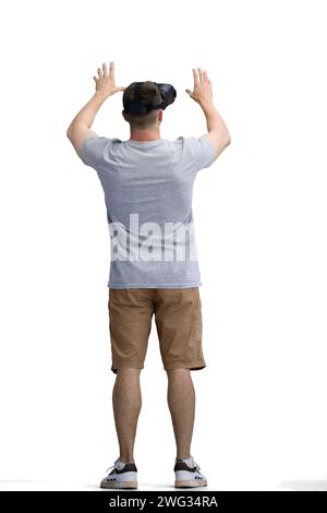 Ein Mann in einem grauen T-Shirt, auf weißem Hintergrund, in voller Länge, mit einer VR-Brille Stockfoto
