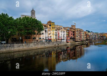 Foto von hell gefleckten Häusern am Ufer des Onyar-Flusses in Gerona, Spanien Stockfoto