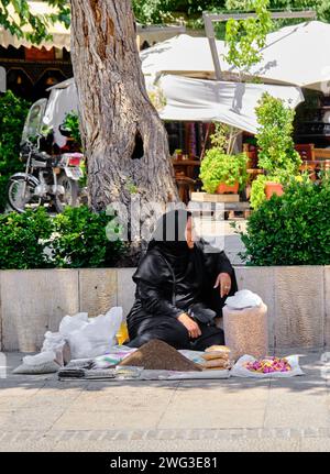 Shiraz, Iran 06.26.2023: Eine alte iranische Frau, verkauft lokale Lebensmittel. Stockfoto