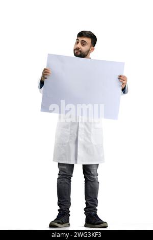 Der Arzt zeigt in voller Höhe auf weißem Hintergrund ein weißes Blatt Stockfoto