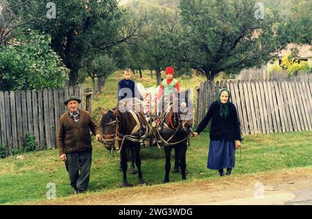 Vrancea County, Rumänien, ca. 2002. Großeltern und Enkelkinder, die mit einem Pferdewagen gefüllt mit Äpfeln aus ihrem Obstgarten kommen. Stockfoto