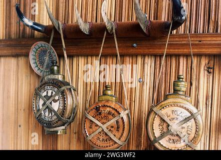 Kreis Ilfov, Rumänien, ca. 2000. Traditionelle hölzerne Kantinen hängen an einem Wandregal mit Tierhörnern als Haken. Stockfoto