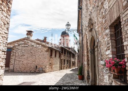 Frontone Italien 16. Mai 2011; sonnige und schattige Seiten der engen mittelalterlichen Kopfsteinpflasterstraße in typisch italienischer Stadt. Stockfoto