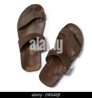 Ein paar alte, gebrauchte Sandalen mit isoliertem weißem Hintergrund, schmutzige, abgenutzte Sohlen und verblasste Riemen, die direkt von oben genommen wurden Stockfoto