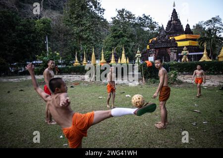 Mae Sai, Thailand. Januar 2024. Einheimische und burmesische Mönche spielen am späten Nachmittag im Wat Tham Pla Tempel Fußball. Wat Tham Pla (Höhlenfischtempel) wird auch als „Affentempel“ für thailändische Einheimische bezeichnet und liegt 16 Kilometer von Mae Sai, der nördlichsten Stadt Thailands, entfernt. (Foto: Guillaume Payen/SOPA Images/SIPA USA) Credit: SIPA USA/Alamy Live News Stockfoto