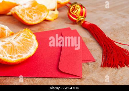 Peal Mandarine Orangen und chinesischer Umschlag für das neue Jahr. Chinesisches Neujahrsfest. Stockfoto