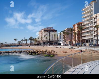 Torrevieja, Alicante, Spanien. Ein wunderschöner Tag Mitte Januar an der Küste von Torrevieja, während die Menschen eine sanfte Brise vom Mittelmeer genießen. Stockfoto