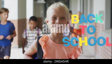 Bild eines bunten Schultextes über lächelndem kaukasienschulmädchen im Schulkorridor Stockfoto