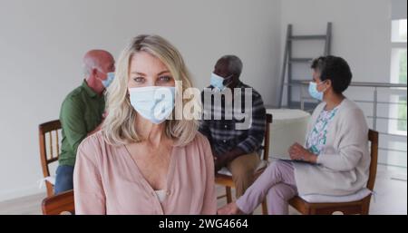 Eine weiße Frau in Maske steht in einem Zuhause Stockfoto