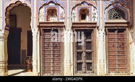 Dekorierte Türen und gemalte Fresken an den Wänden des Kamal Morarka Haveli Museums, Nawalgarh, Rajasthan, Indien. Stockfoto