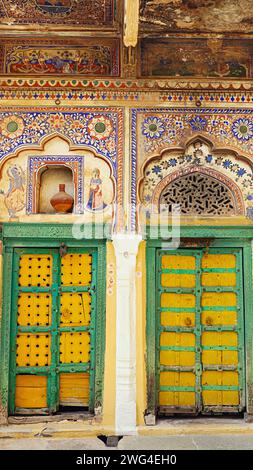 Gemälde an der Wand und farbenfrohe Türen von Shri Pushkar thalia Haveli, Mandawa, Jhunjhunu, Rajasthan, Indien. Stockfoto
