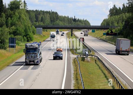 Salo, Finnland. Juli 2019. Sommer Autobahnlandschaft mit Transportwagen, linker Massentransporter Mercedes-Benz Actros Xtar von Kuljetus Auvinen Oy. Stockfoto