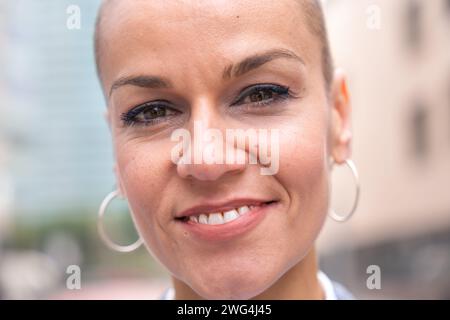 Porträt-Nahaufnahme einer lächelnden Geschäftsfrau, die draußen in die Kamera schaut. Stockfoto