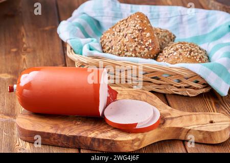 Gekochte Schinkenwurst, geschnitten auf hölzernem Küchenbrett. Stockfoto