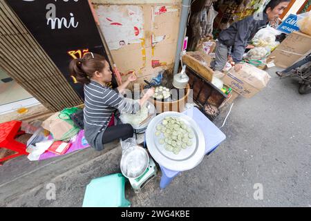 Vietnam, Hanoi, Straßenverkäufer, der Essen auf dem Gehweg zubereitet und kocht. Stockfoto