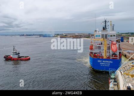 Das BBC Marmara General Cargo Schiff wird von einem lokalen Tug von Port Gentil aus vom Kai abgeschleppt. Stockfoto