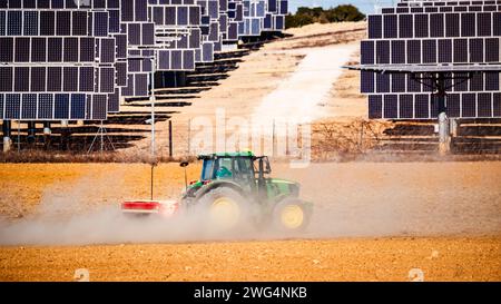 Traktor pflügt ein Feld neben einem Solarpark in El Bonete Stockfoto