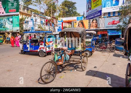 Ein lokaler Rikscha-Fahrer, der in einer Straßenszene im geschäftigen Stadtzentrum von Chandannagar (Chandernagore), Westbengalen, Indien, auf Geschäfte wartet Stockfoto