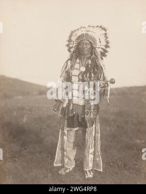 High Hawk, 1907. Das Foto zeigt das Porträt des Hohen Falken in voller Länge, mit Blick auf die Vorderseite, stehend, mit Kriegshaube, zeremonieller Kleidung, Medaillon und einen Putschstock halten. Stockfoto